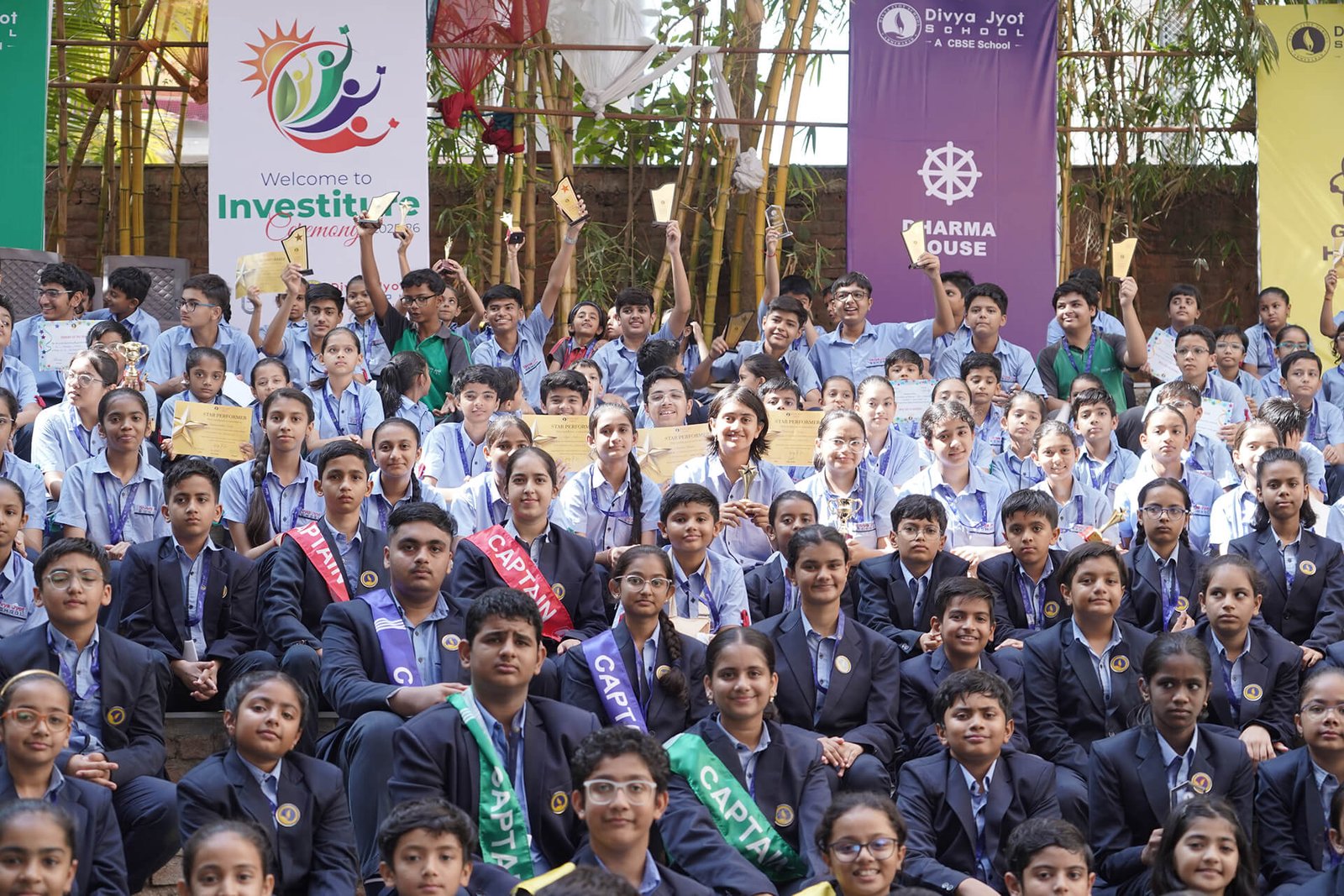 Group photo of school students in uniform holding certificates at an award ceremony event