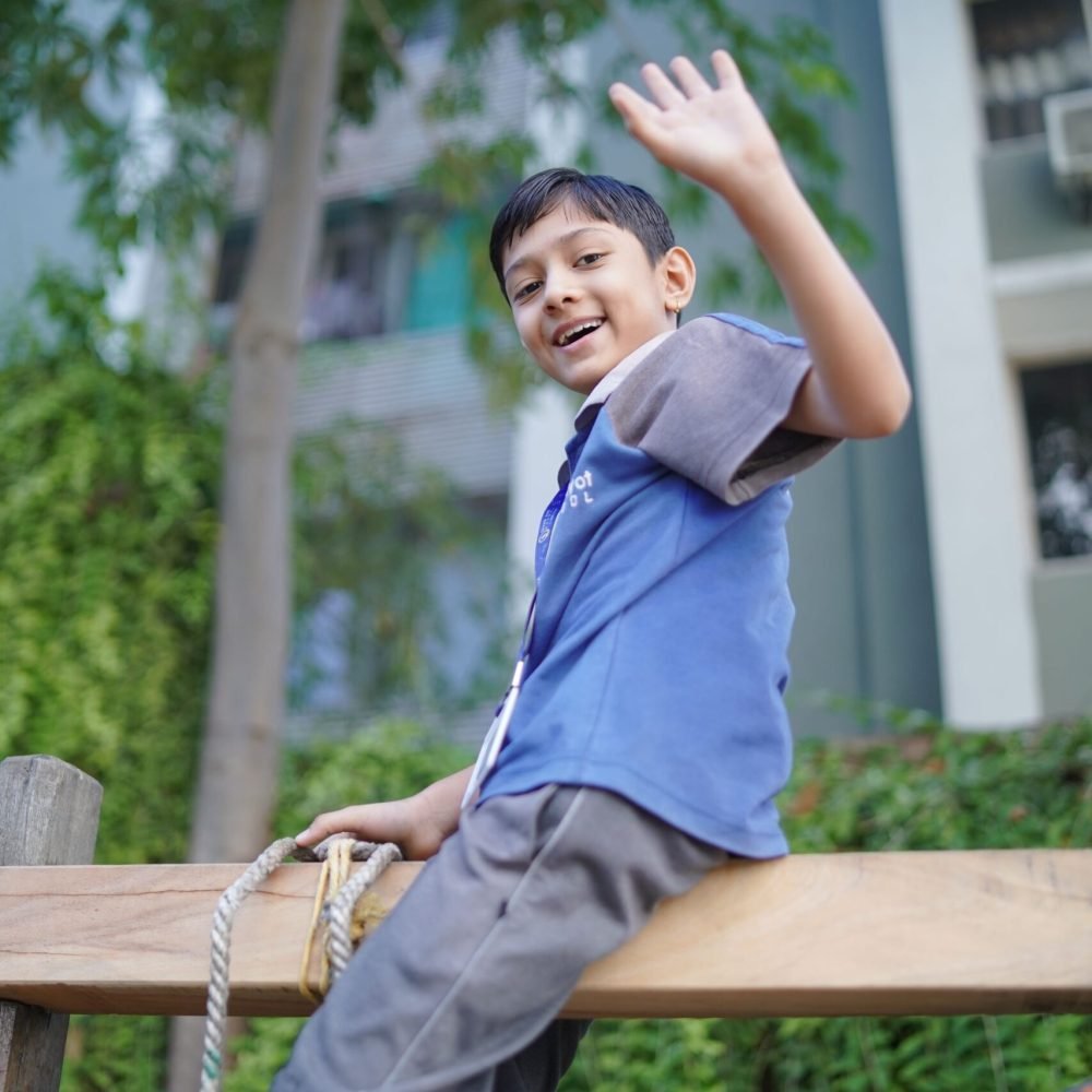Young Student Waving on Outdoor Playground Equipment
