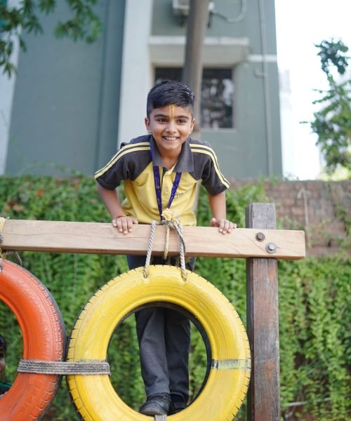 Young Student Playing on Tire